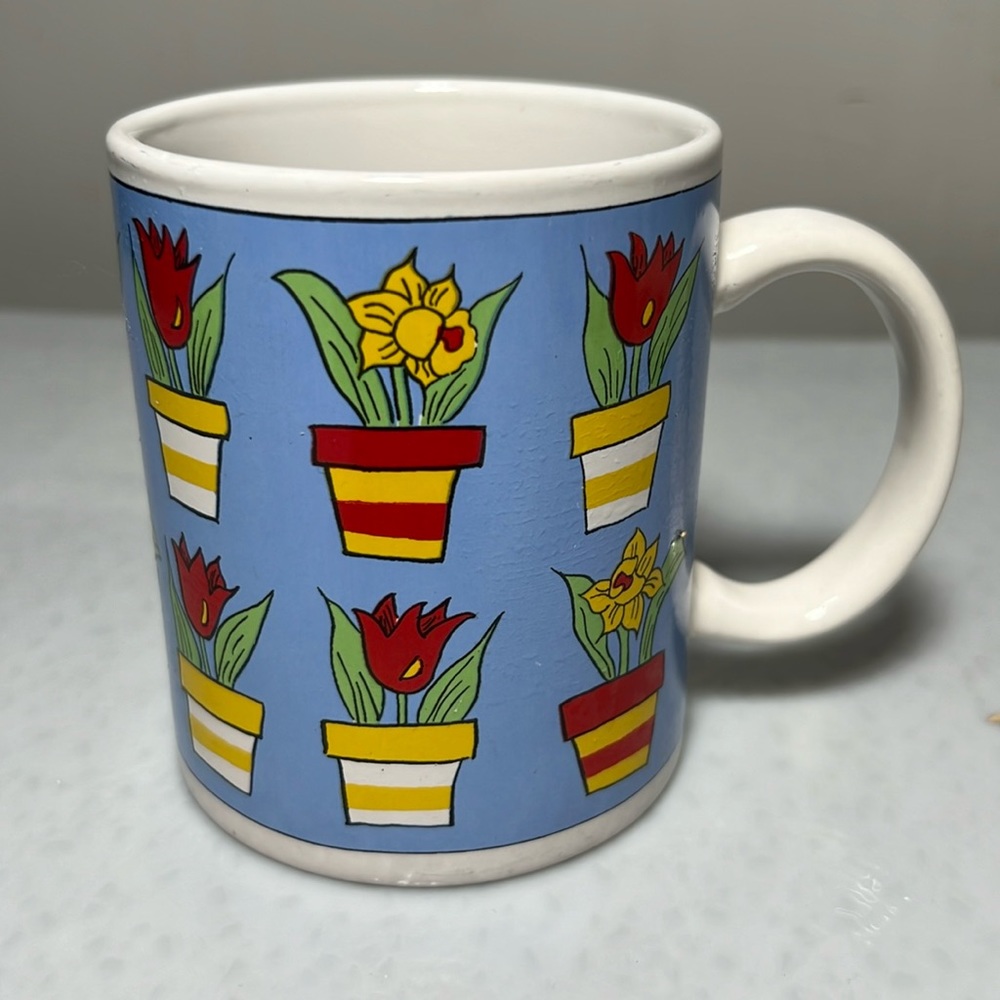 Vintage Ceramic Mug with Potted Flowers Around it.